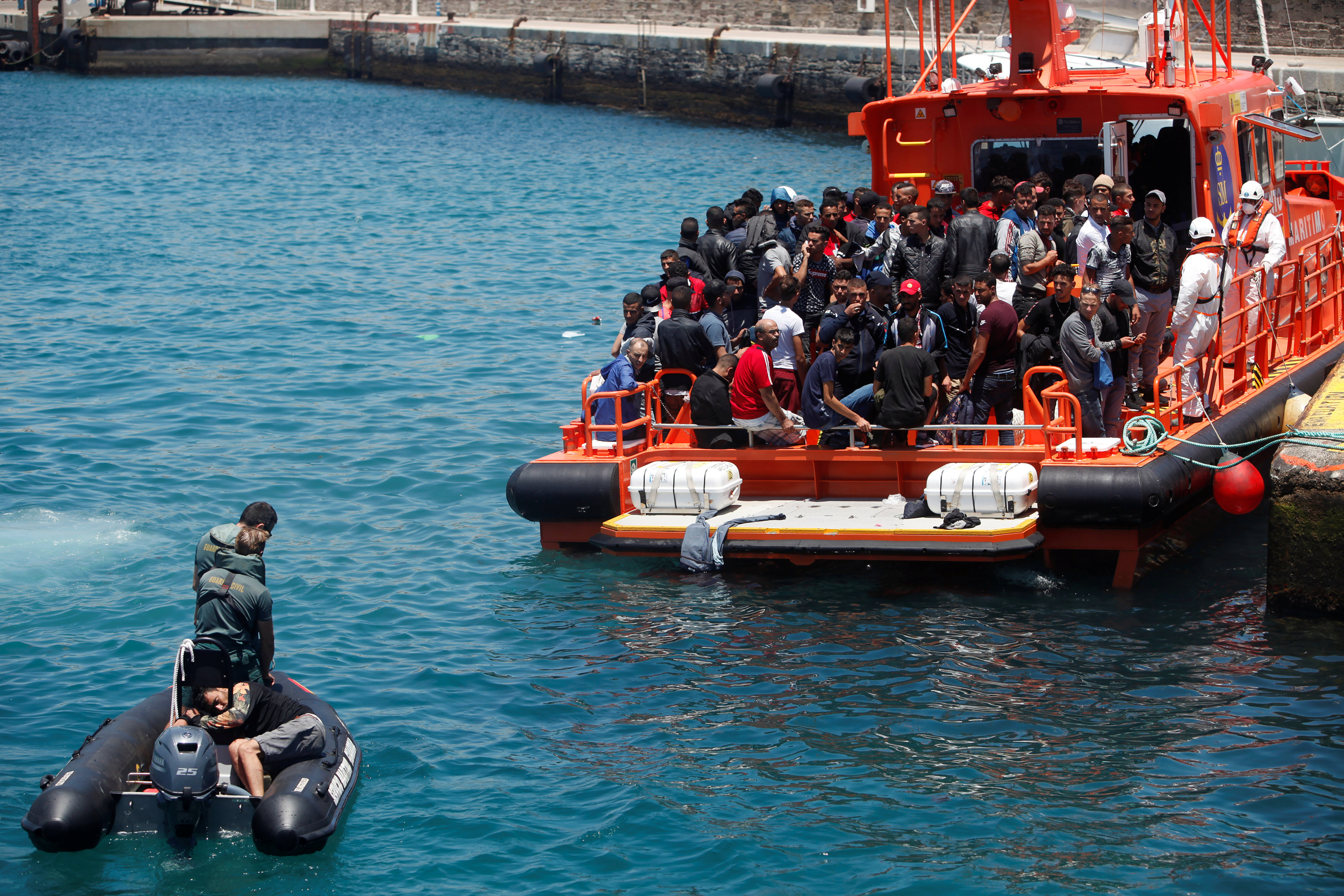 مهاجر تم اعتراضه على متن قارب خشبي تم إنقاذه من قبل حراس إسبان بعد قفزه في البحر من قارب الإنقاذ لدى وصوله إلى ميناء تريفة ، جنوب اسبانيا في 6 يوليو ، 2018. جون نازكا/رويترز