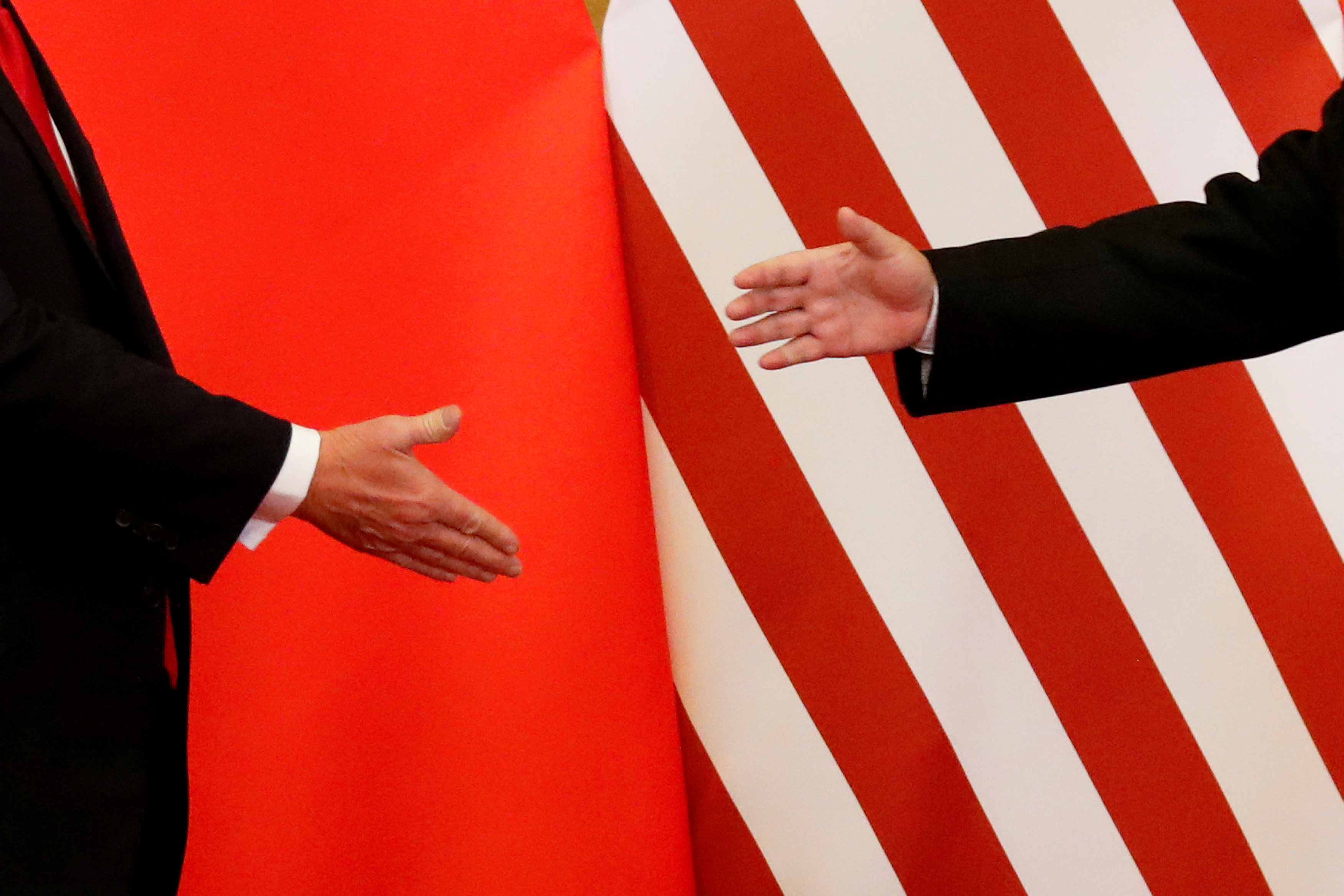 صورة أرشيفية لمصافحة الرئيس الأميركي دونالد ترامب (يمين) مع الرئيس الصيني شي جين بينج (يسار) بعد لقائهما في بكين، 9 نوفمبر 2017. رويترز