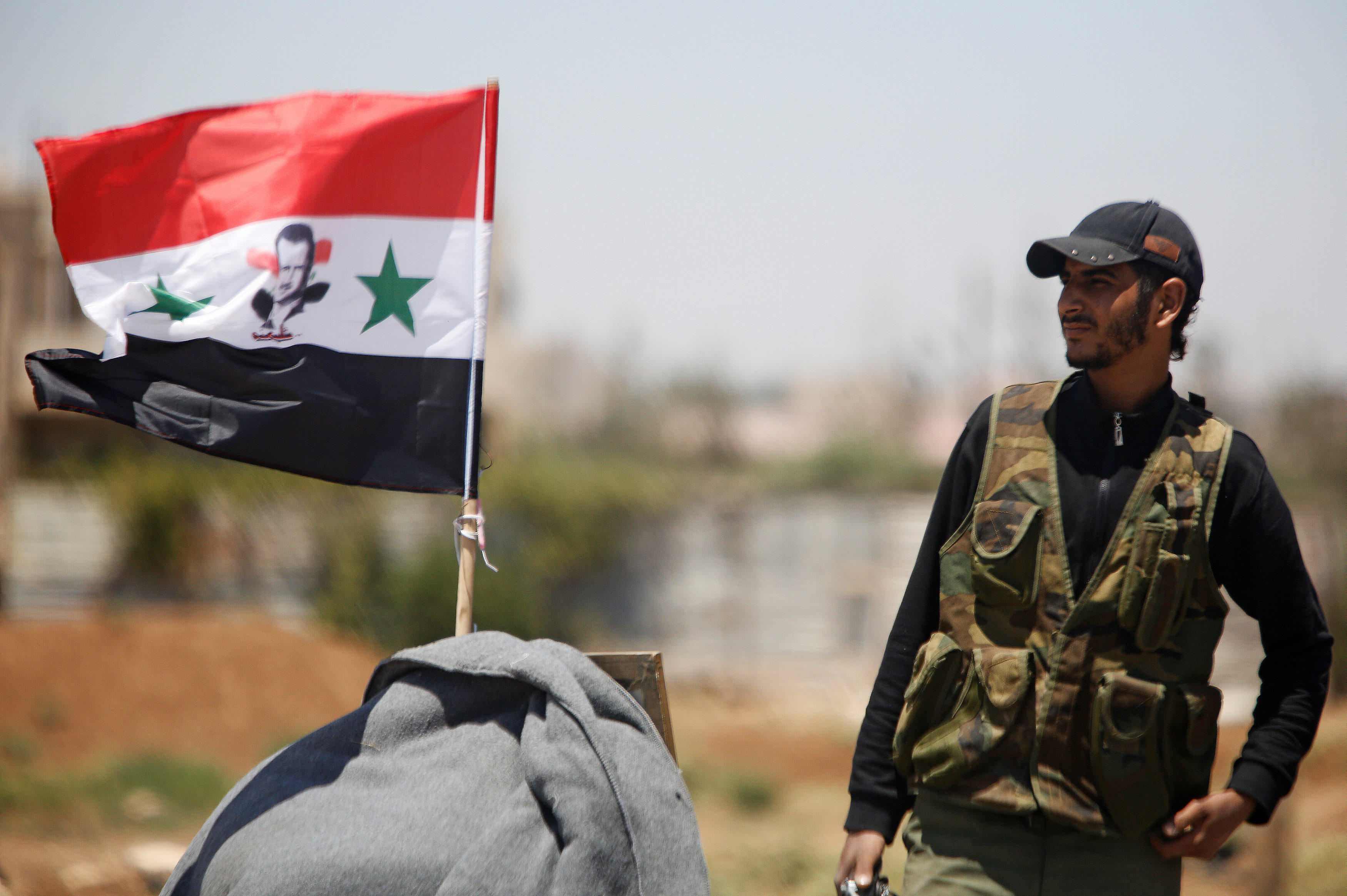 الجيش السوري يرفع علم الجمهورية بعد سيطرته على مناطق في درعا، 10 يوليو 2018. عمر صناديقي/ رويترز