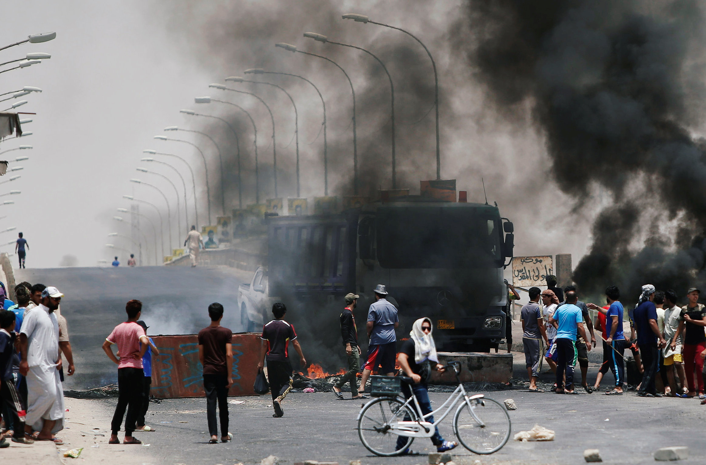 محتجون عراقيون يحرقون اطارات ويغلقون طرق مؤدية إلى مدينة البصرة في جنوب العراق، 12 يوليو 2018. عصام السوداني/ رويترز 