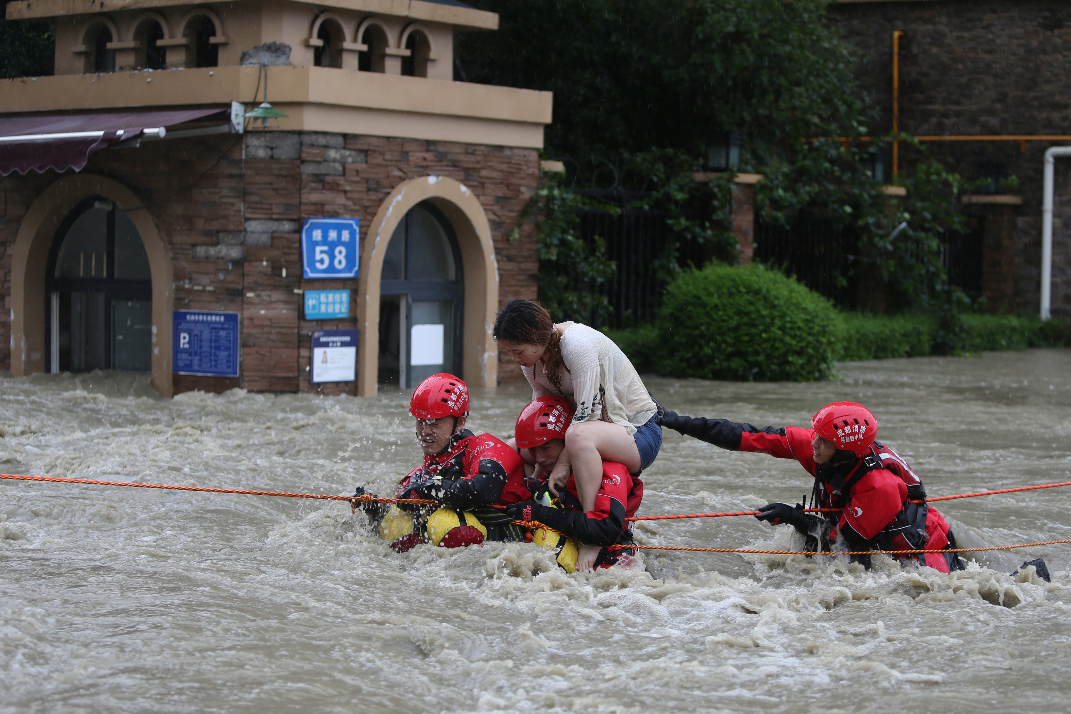 رجال الإطفاء ينقذون امرأة وسط الفيضانات في الصين. 11 يوليو 2018. وانغ هونغ تشيانغ/ رويترز