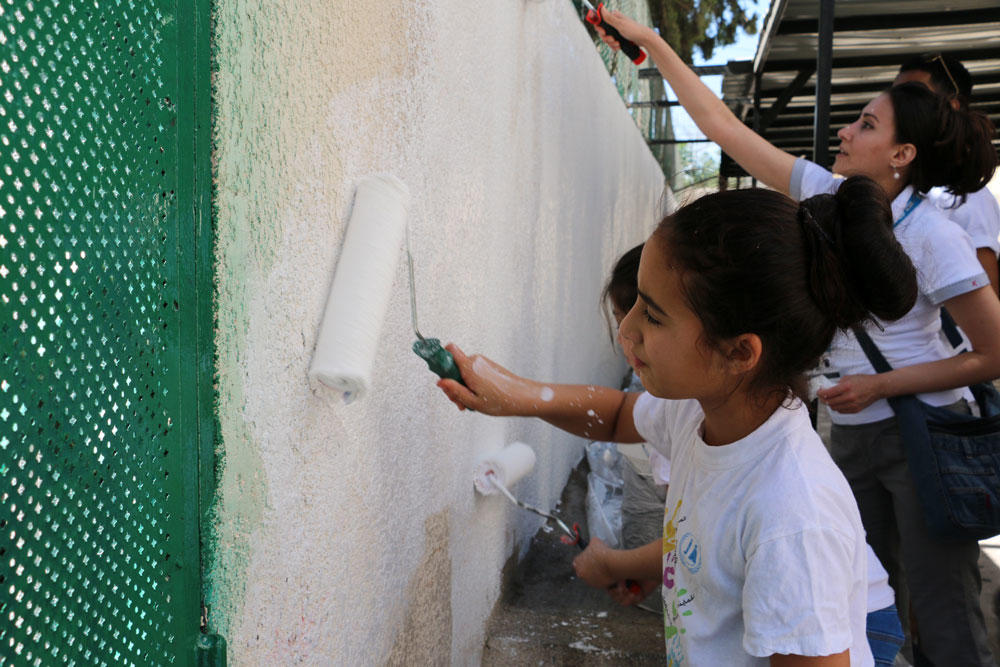 طلاب في مدرسة جبل عمان المختلطة يقومون بدهان الجدران. أونروا 