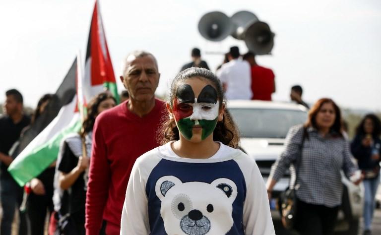 فتاة ترسم على وجهها علم فلسطين في مظاهرة لعرب 48 في قرية دير حنا بمناسبة يوم الأرض. 30 مارس 2017. ا ف ب
