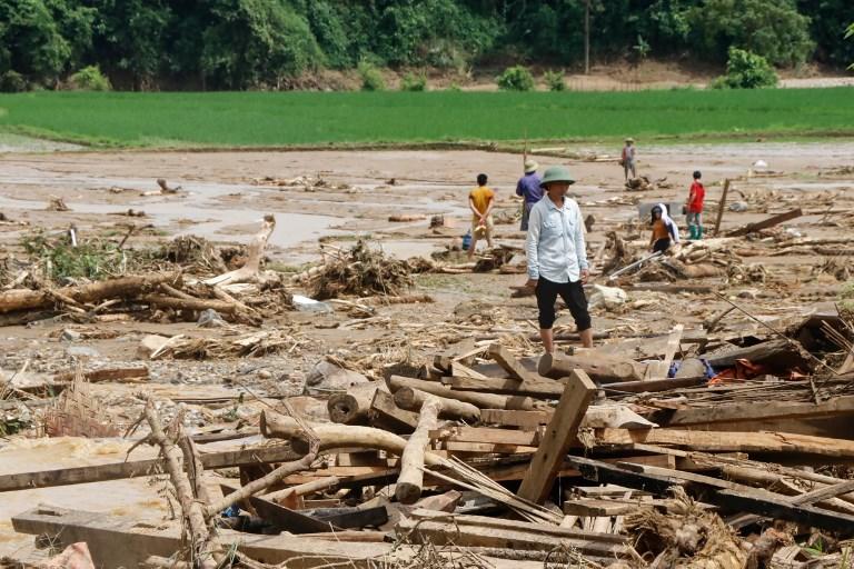 سكان يزيلون الحطام في قرية تضررت من الفيضانات المفاجئة في مقاطعة ين باي في فيتنام في 21 يوليو عام 2018. انه توان/ أ ف ب