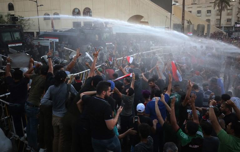 قوات أمن عراقية ترش المياه على عدد من المتظاهرين في ميدان التحرير ببغداد. 20 يوليو 2018. أحمد الربيعي/ أ ف ب