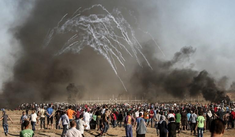متظاهرون فلسطينيون يجتمعون أثناء إطلاق القوات الإسرائيلية لقنابل الغاز المسيل للدموع شرق مدينة غزة في 27 يوليو 2018. محمود حمس/ أ ف ب