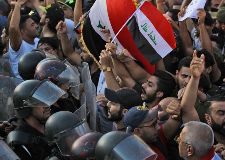 متظاهرون عراقيون يرددون شعارات وتصادم مع قوات الأمن خلال مظاهرة ضد البطالة ونقص الخدمات الأساسية في ميدان التحرير ببغداد في 20 يوليو 2018. أ ف ب