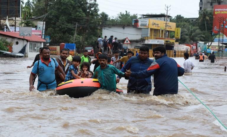 متطوعون هنديون يساعدون في إجلاء السكان المحليين في قارب في منطقة سكنية، في ولاية كيرالا الهندية في 17 أغسطس 2018. أ ف ب