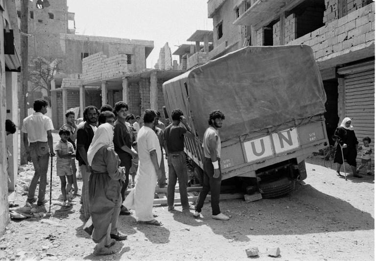 لاجئون فلسطينيون يقفون حول سيارة تابعة لأونروا في مخيم البقعة للاجئين الفلسطينيين قرب العاصمة عمان في عام 1970. ا ف ب/أرشيف أونروا