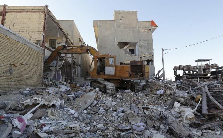 صورة أرشيفية لآلية تسحب ركام المنازل إثر زلزل ضرب إحدى المدن الإيرانية. أ ف ب