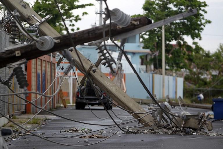 صورة أرشيفية لأعمدة خطوط الكهرباء سقطت بسبب مرور إعصار ماريا في شارع في سان خوان، بورتوريكو في 7 نوفمبر 2017. ريكاردو أردونغو/ أ ف ب
