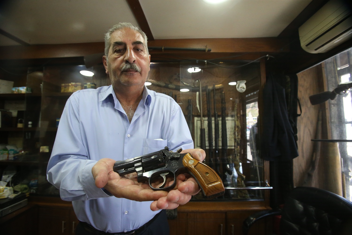 صورة أرشيفية لأحمد الزاهري، صاحب أقدم معرض لبيع السلاح في عمان يعرض مسدس ماغنوم عيار 357 في معرض الزاهري في وسط البلد. صلاح ملكاوي/المملكة.