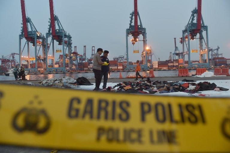 صورة التقطت في ميناء تانجونج بريوك في جاكرتا في 30 أكتوبر 2018 تظهر شرطيين إندونيسيين يفحصان حطام الطائرة المنكوبة "ليون إير". أديك بيري / أ ف ب