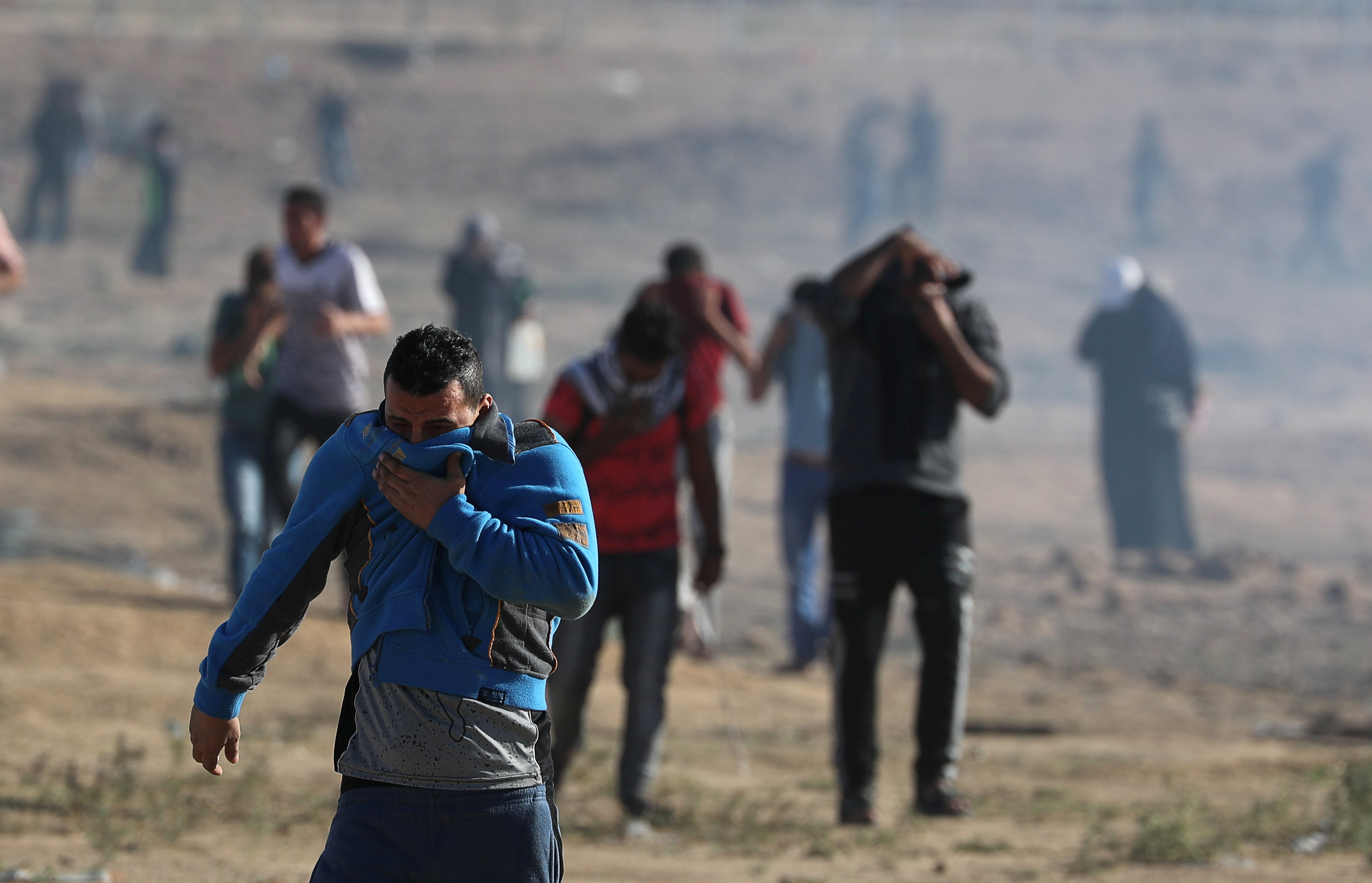 فلسطينيون يحاولون الابتعاد عن قنابل الغاز المسيل للدموع الذي أطلقه جيش الاحتلال الإسرائيلي على قطاع غزة، 2 نوفمبر 2018. محمد سالم/ رويترز 