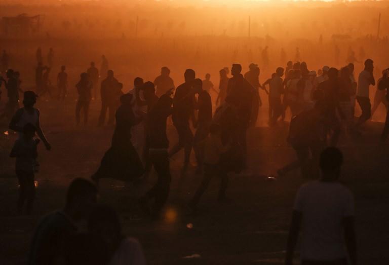 متظاهرون فلسطينيون يركضون من الغاز المسيل للدموع الذي أطلقته قوات الاحتلال الإسرائيلي خلال اشتباكات في شرق مدينة غزة.2 نوفمبر 2018. أ ف ب