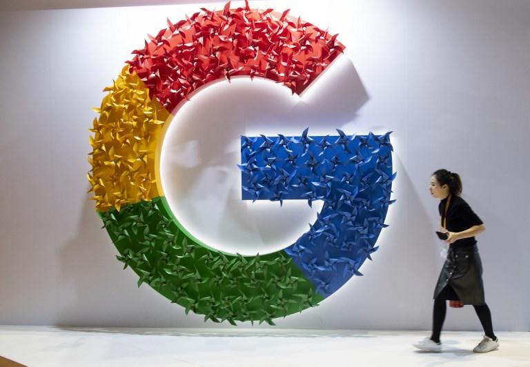 امرأة تمر أمام شعار Google في معرض الصين الدولي. أ ف ب