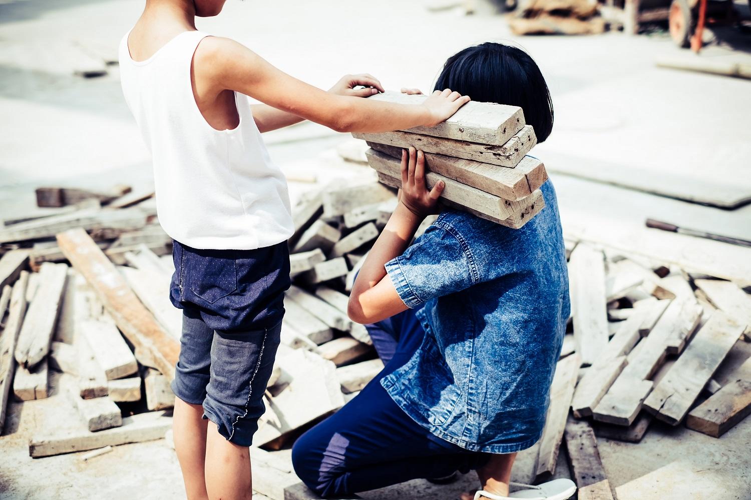 صورة تعبيرية لطفلين يعملان على رفع الخشب. (shutterstock)