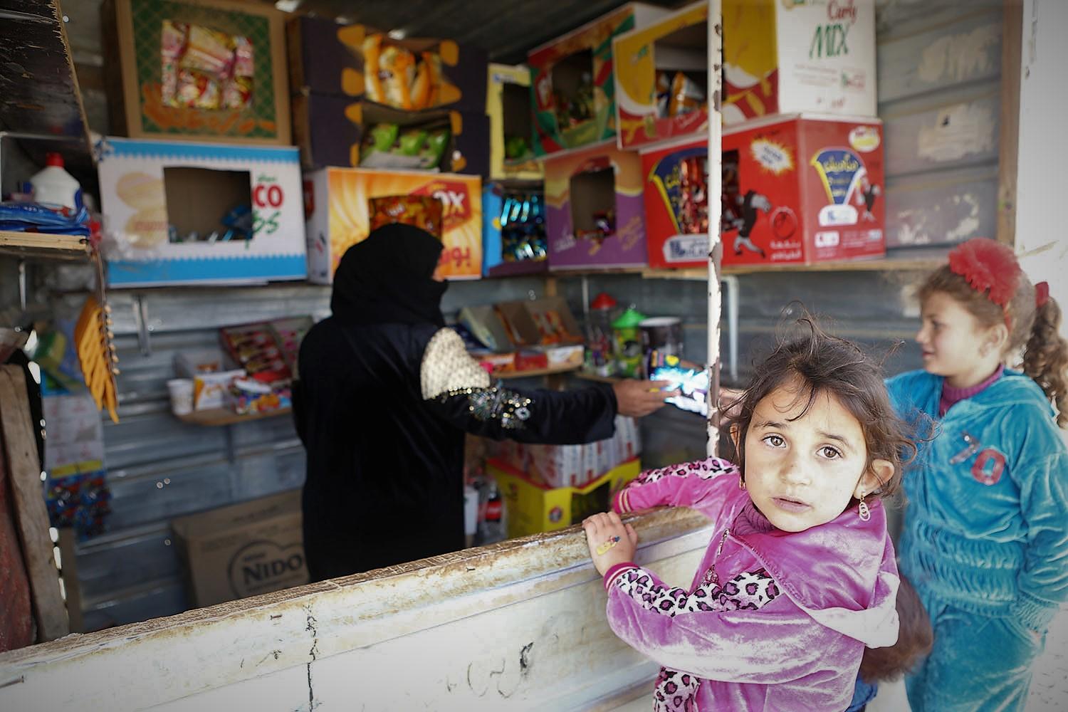 طفلتان تقفان أمام بقالة لشراء حاجاتهن في مخيم الزعتري. صلاح ملكاوي/ المملكة