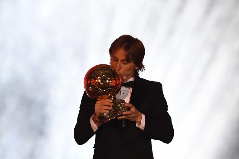 الكرواتي مودريتش مقبلاً جائزة الكرة الذهبية في العاصمة الفرنسية باريس. فرانك فيف/ أ ف ب