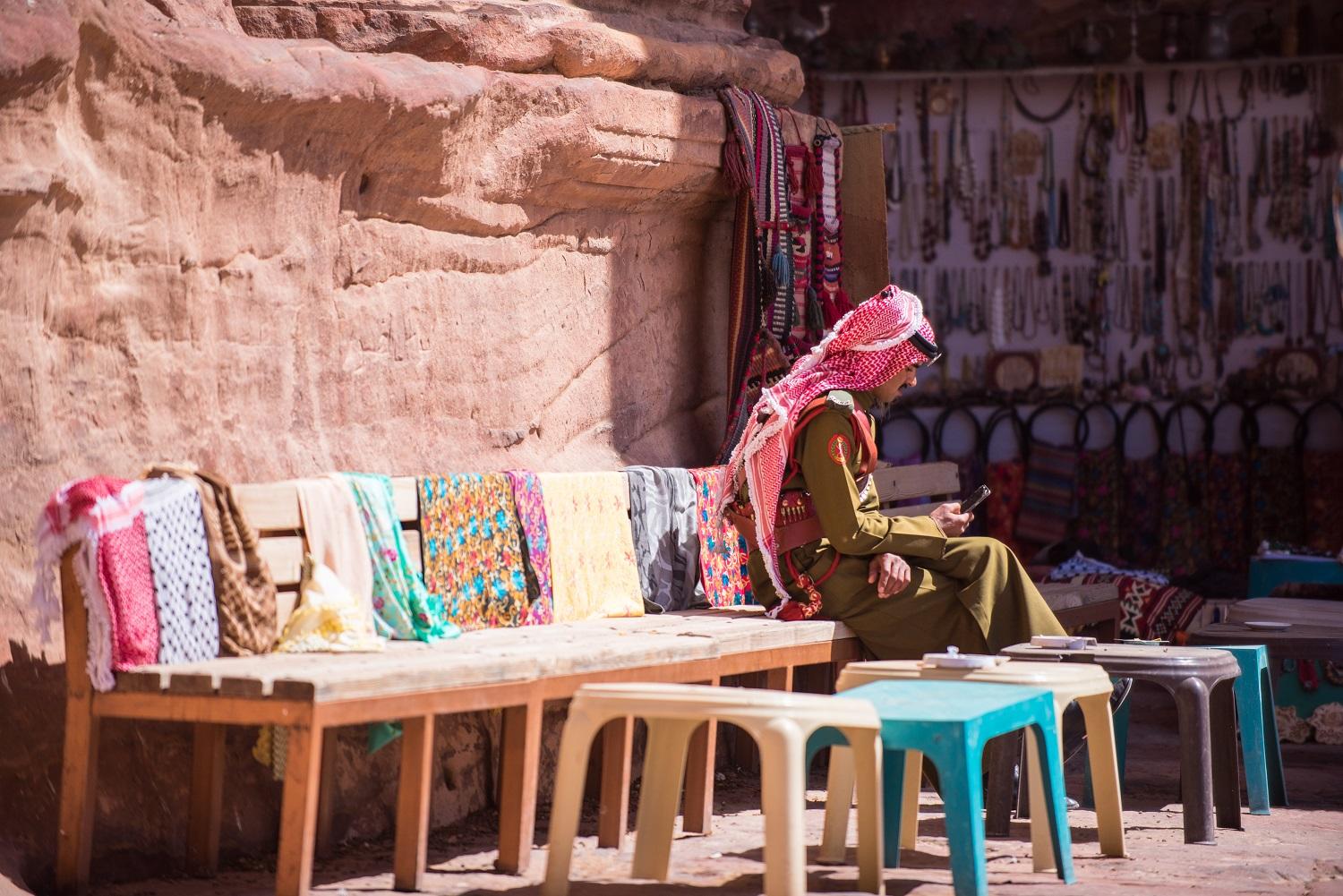 صورة لفرد من قوات البادية الأردنية في منطقة البترا يستخدم هاتفاً خلوياً. imeduard /Shutterstock.com