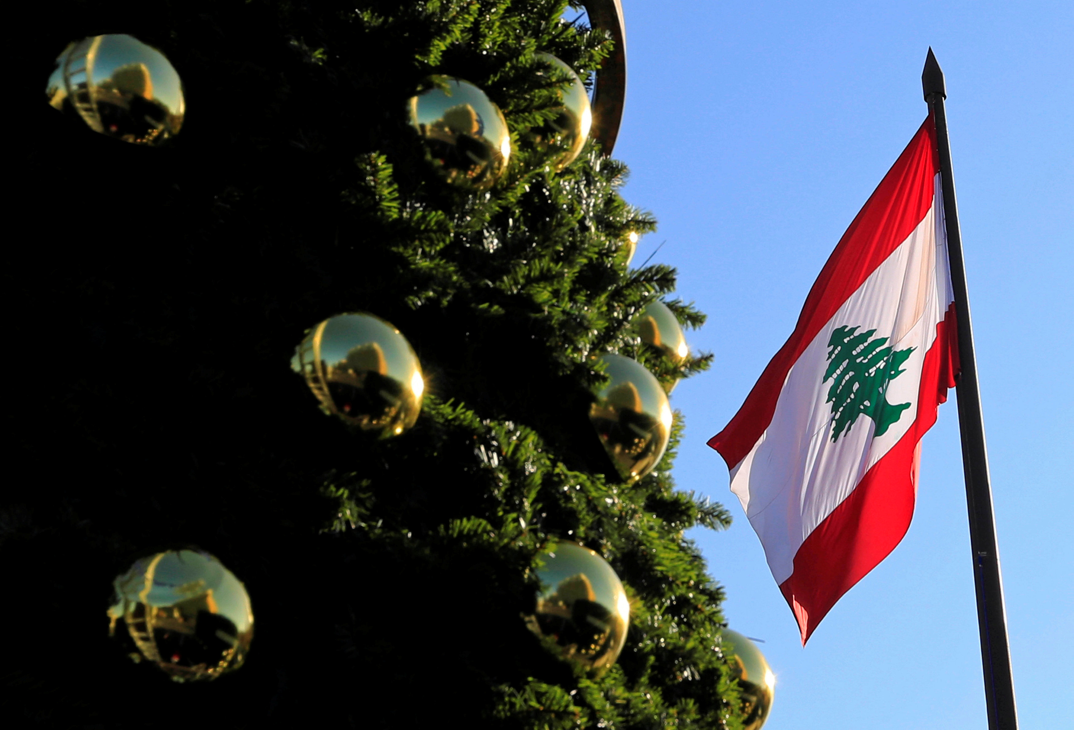 العلم اللبناني مرفوع بجانب شجرة لعيد الميلاد في ساحة الشهداء في العاصمة اللبنانية، بيروت. رويترز 