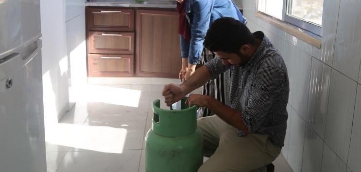 أحد المواطنين يغير أسطوانة الغاز في منزله في عمان. 9 يونيو 2018. ا ف ب