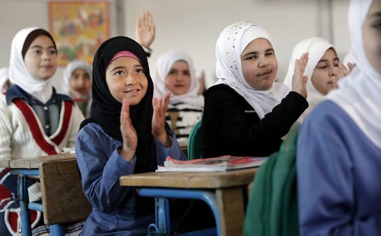 طالبات سوريات على مقاعد الدراسة في مخيم الزعتري للاجئين في محافظة المفرق شمالي الأردن. (أ ف ب)