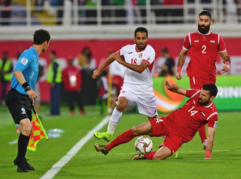 المهاجم الأردني موسى التعمري يحاول المرور أمام أحد لاعبي المنتخب السوري. أ ف ب