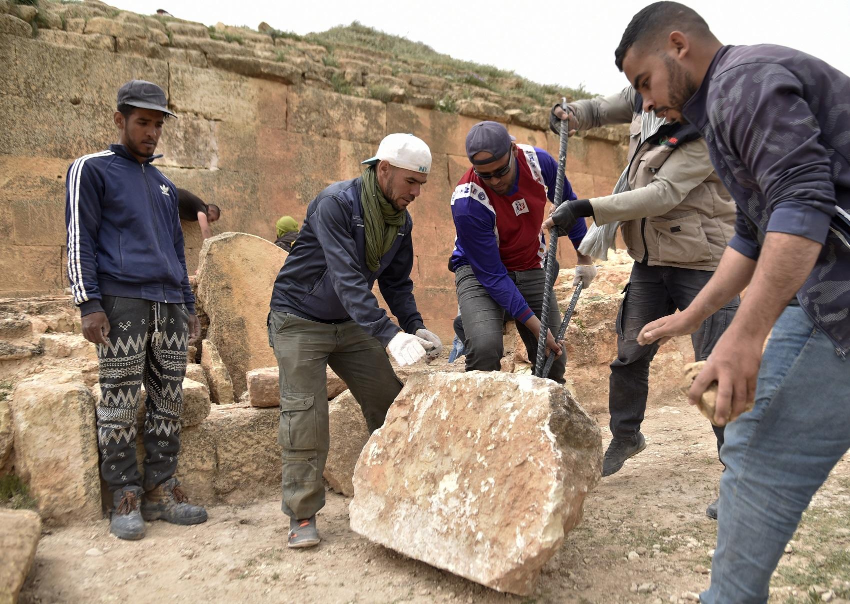 طلاب ومختصون من معهد الآثار في جامعة الجزائر يعملون في أحد مواقع أهرامات لِجدار، شمال الجزائر. رياض كرمدي/أ ف ب