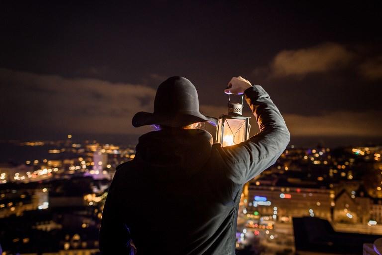 الحارس البديل لحارس مدينة لوزان السويسرية يحمل فانوسًا بينما ينظر من برج جرس كاتدرائية لوزان، 17 ديسمبر 2018. فابريس كوفريني/ أ ف ب