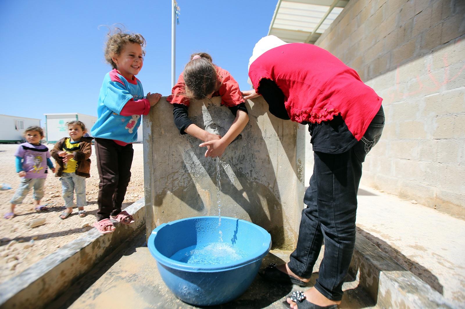 أطفال يملؤون وعاء ماء في مخيم الزعتري للاجئين السوريين في محافظة المفرق شمالي الأردن. صلاح ملكاوي/ المملكة