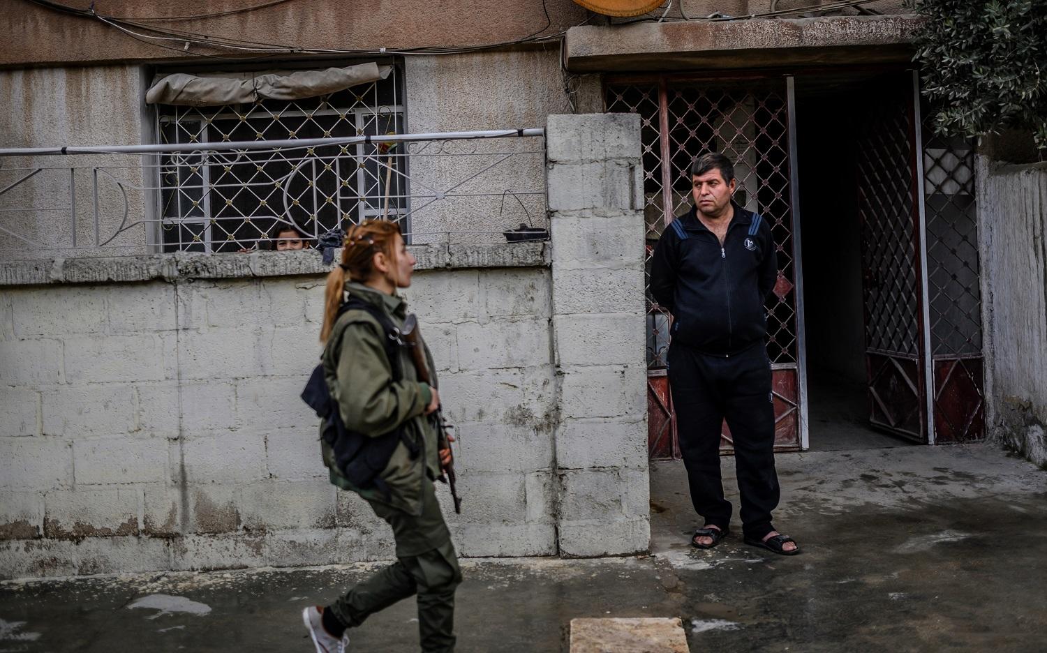 رجل ينظر إلى مقاتلة من قوات سوريا الديمقراطية. 15 فبراير 2019 . ا ف ب 