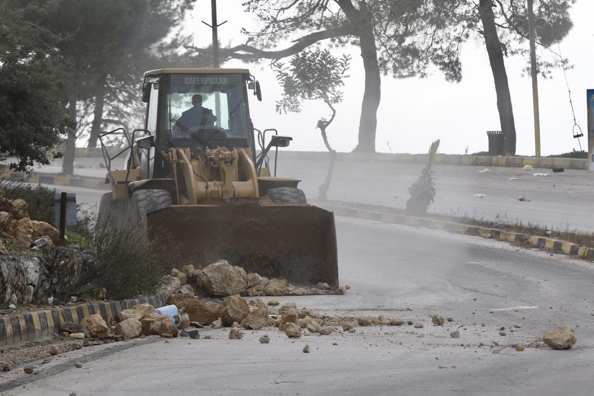 آلية تابعة لبلدية عنجرة تزيل حجارة من الشارع الرئيسي. صلاح ملكاوي / المملكة