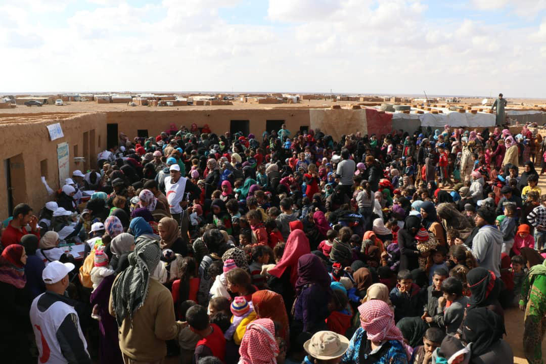 صورة للصليب الأحمر السوري تظهر نازحين في مخيم الركبان يتنظرون للحصول على مطاعيم، 5 نوفمبر 2018. أ ف ب 
