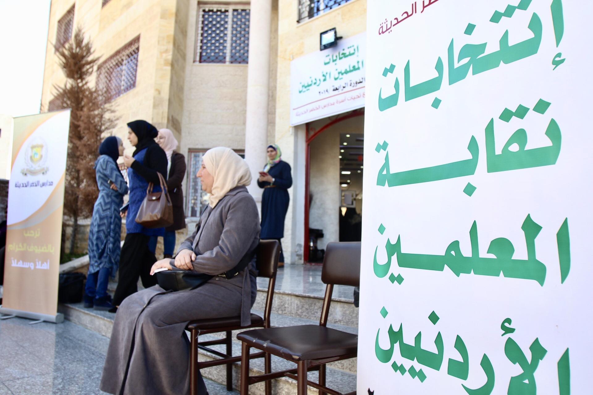 معلمة تجلس أمام مدخل لجنة اقتراع في مدارس الخضر في طبربور في عمّان. صلاح ملكاوي/ المملكة 