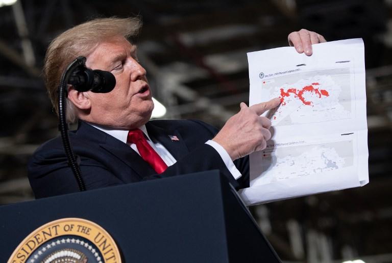 الرئيس الأميركي دونالد ترامب يحمل خريطة توضح تفاصيل خسائر  تنظيم "داعش"، 20 مارس 2019. سول لوب/ أ ف ب