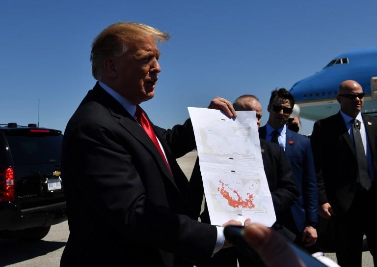 الرئيس الأميركي يعرض خريطة تظهر المساحات التي كان يحتلها داعش، والثانية خالية تظهر الوضع الجمعة. نيكولاس كام/ أ ف ب
