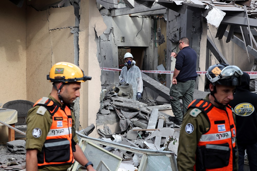 شرطة وجنود الاحتلال يتفقدون منزلاً متضرراً أصيب به صاروخ شمالي تل أبيب. 25 مارس 2019. رويترز