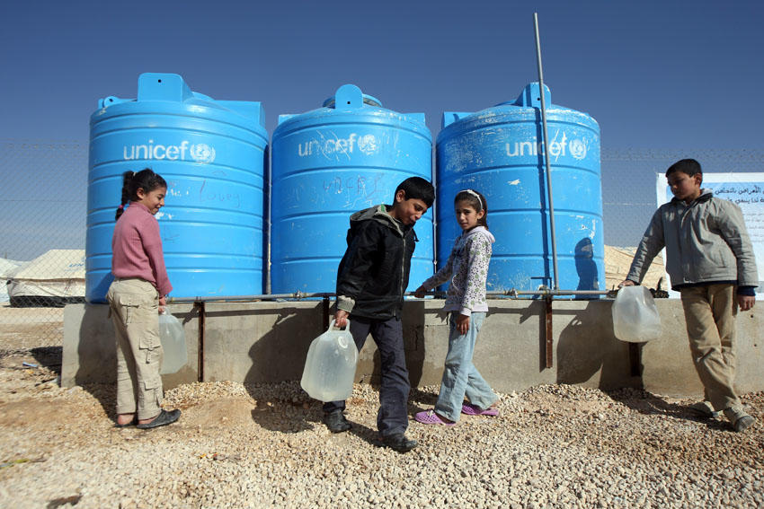 أطفال يملؤون أوعية بالماء في مخيم الزعتري للاجئين السوريين في محافظة المفرق شمالي الأردن. صلاح ملكاوي / المملكة