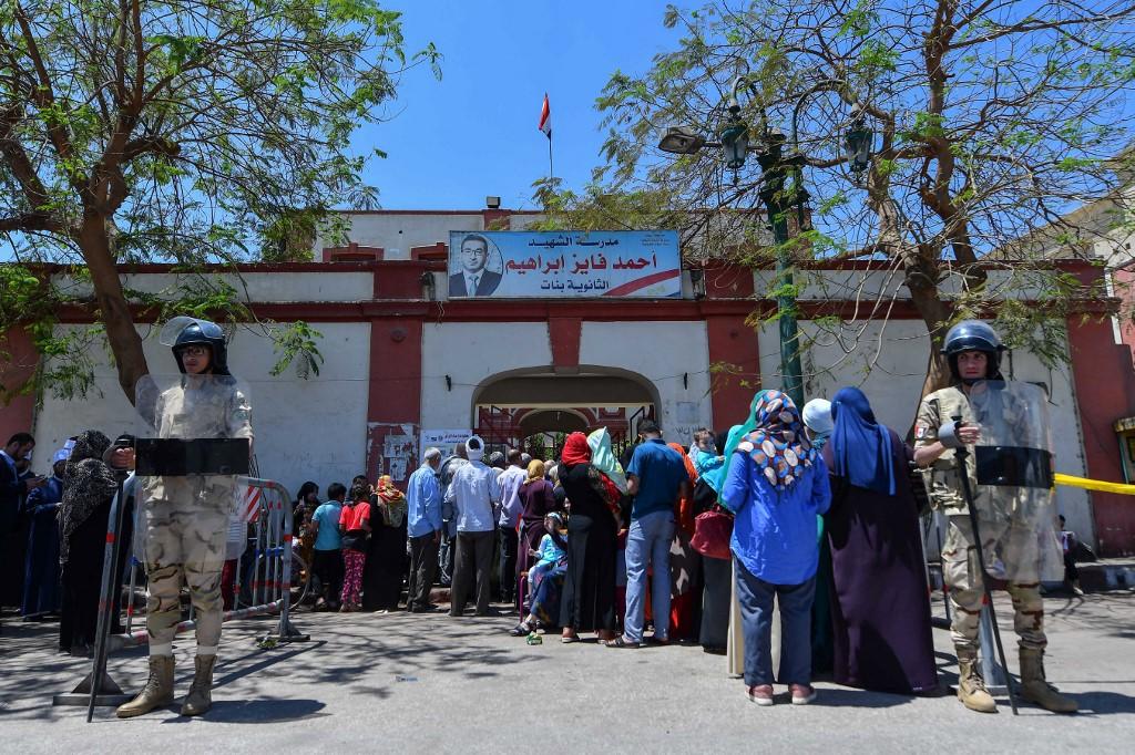 ناخبون مصريون ينتظرون في طابور للتصويت في استفتاء على التعديلات الدستورية .أحمد حسن / أف ب 