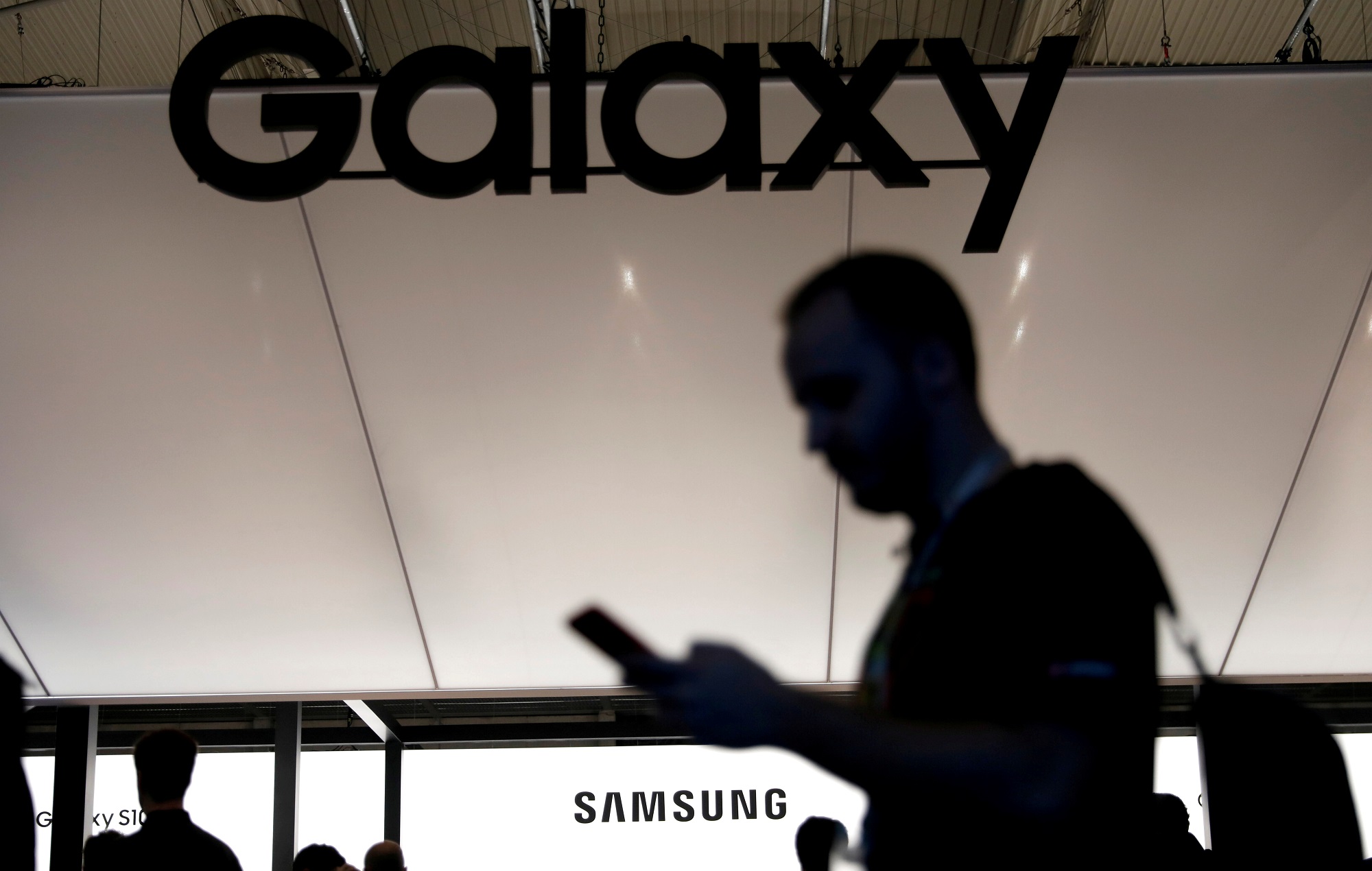 شخص يستخدم هاتفًا محمولًا في كشك Samsung في مؤتمر Mobile World Congress في برشلونة. 26 فبراير 2019. رويترز