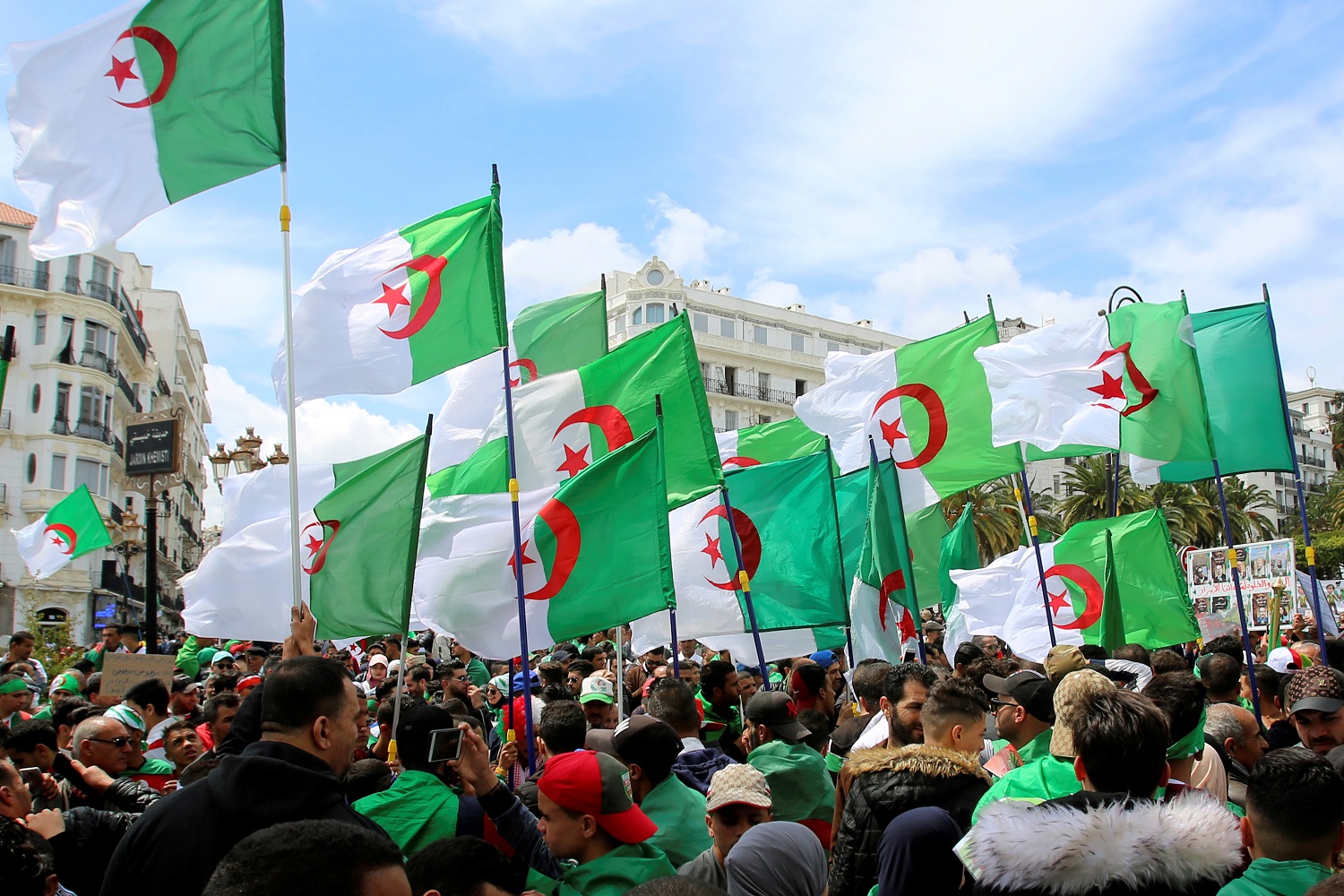 جزائريون يحملون علم بلادهم أثناء مشاركتهم في تظاهرة ضد الطبقة الحاكمة، 12 أبريل 2019. رويترز 