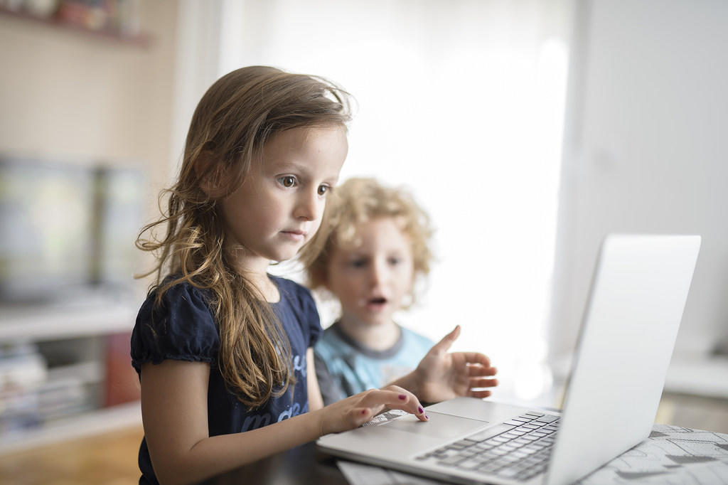 طفلتان في السادسة والرابعة من عمرهما تستخدمان حاسوب محمول. (الأمم المتحدة)
