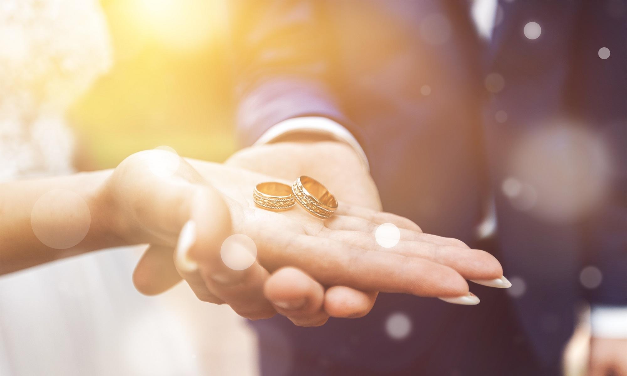 زوجان يحملان خاتما الزواج. shutterstock