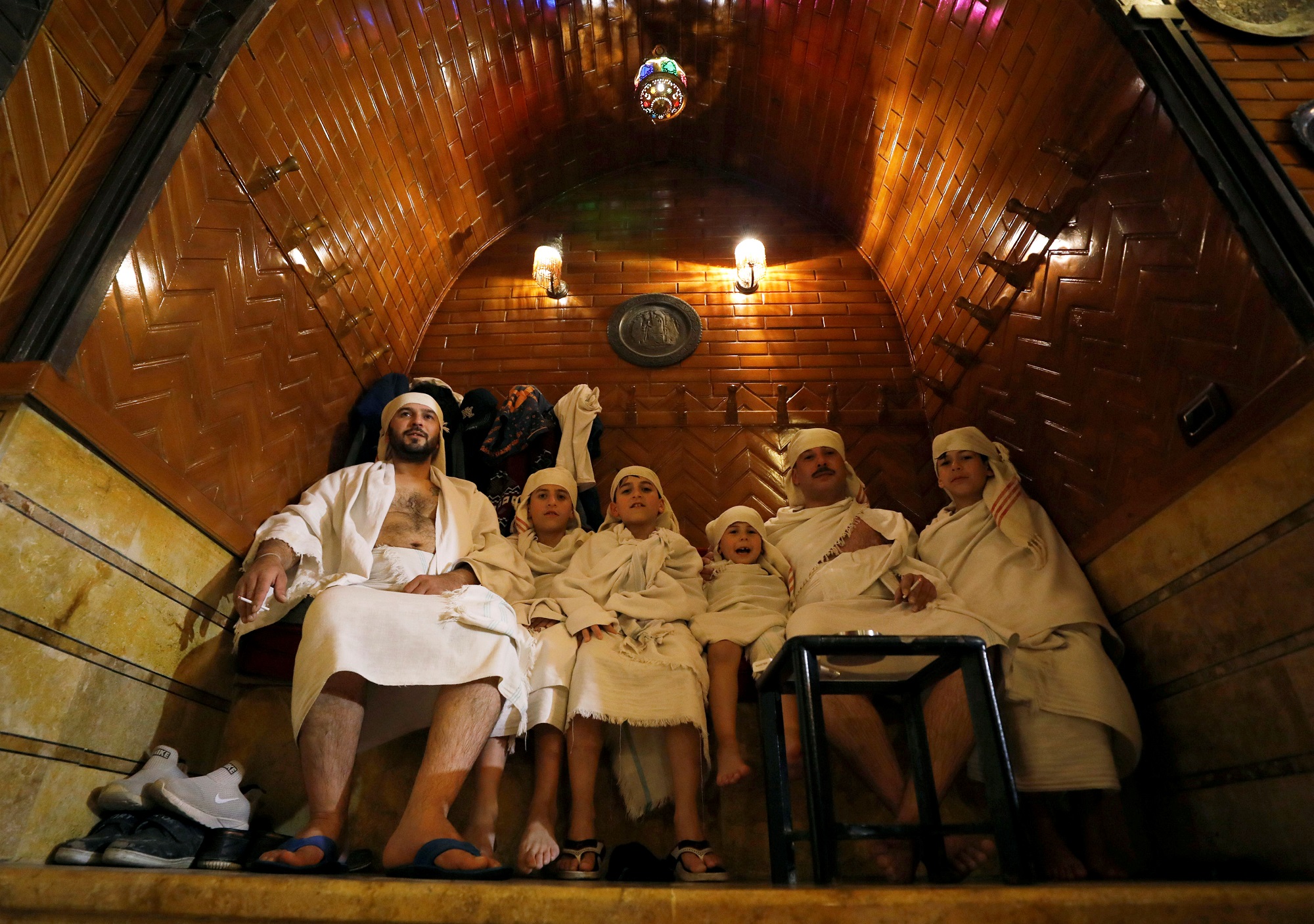 أفراد من أُسرتي منصور ووفائي يرتدون ملابس حمام شعبي في باب الأحمر في حلب السورية. 11 أبريل 2019. رويترز / عمر صناديقي