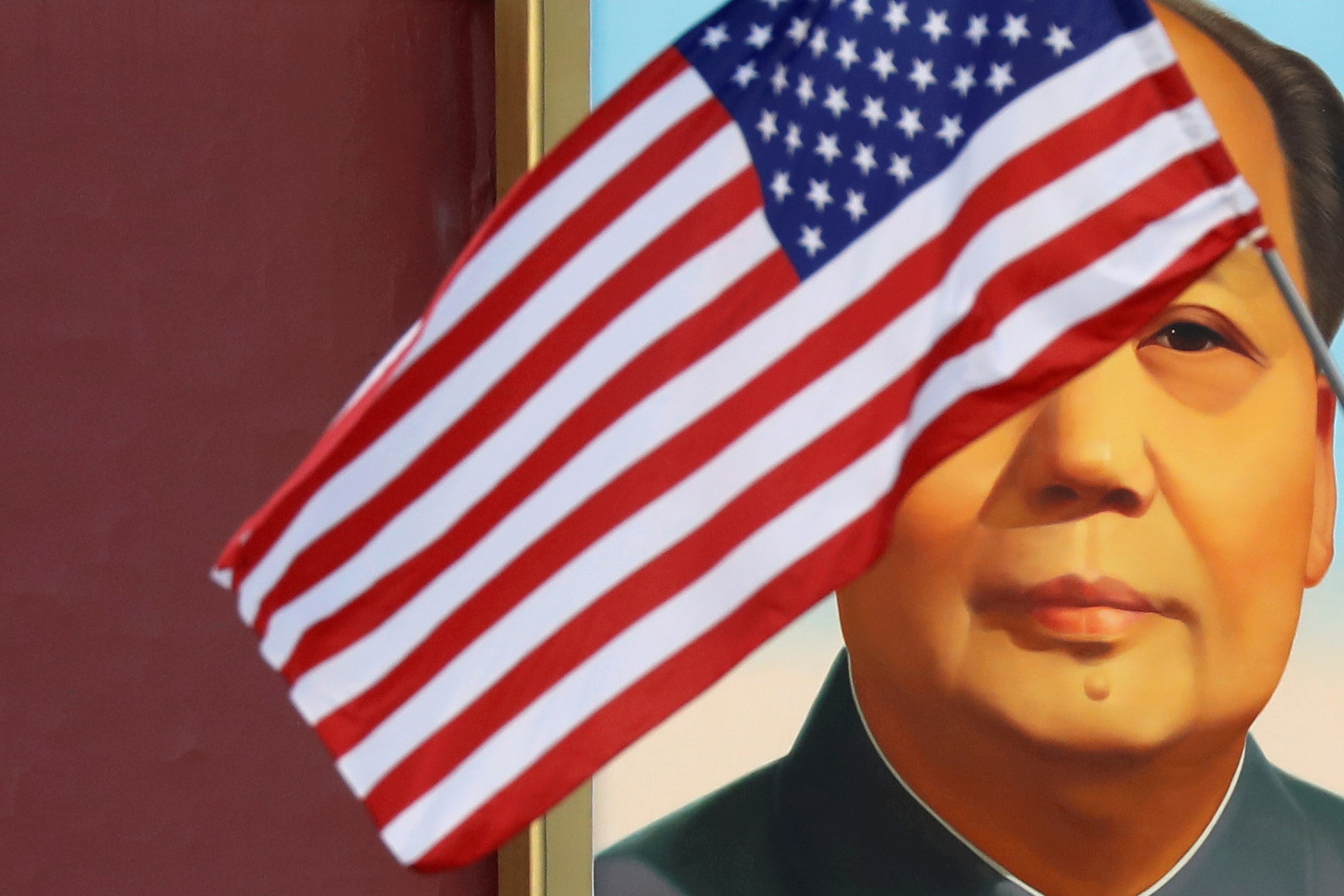 العلم الأميركي يرفرف أمام صورة للرئيس الصيني الراحل ماو تسي تونغ أثناء زيارة الرئيس الأميركي دونالد ترامب إلى بكين، 8 نوفمبر 2017. رويترز