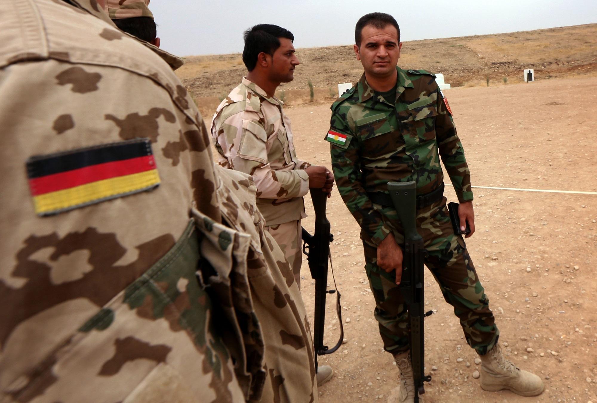 خبير عسكري ألماني خلال تحدثه لجندي من كردستان العراق خلال تدريبات. أ ف ب 
