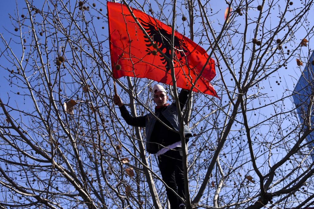شاب يلوح بالعلم الوطني لألبانيا في بريشتينا في كوسوفو، خلال استعراض للاحتفال بالذكرى الحادية عشرة لإعلان استقلال كوسوفو، 17 شباط/فبراير 2019. أ ف ب
