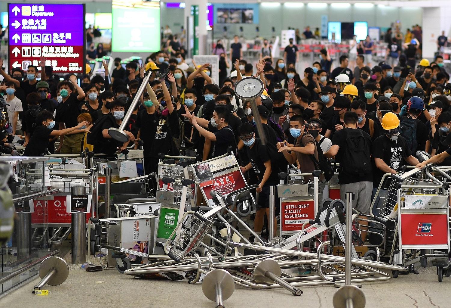 متظاهرون يغلقون مدخل بوابة في مطار هونغ كونغ الدولي، 13 آب/ أغسطس 2019. (أ ف ب) 
