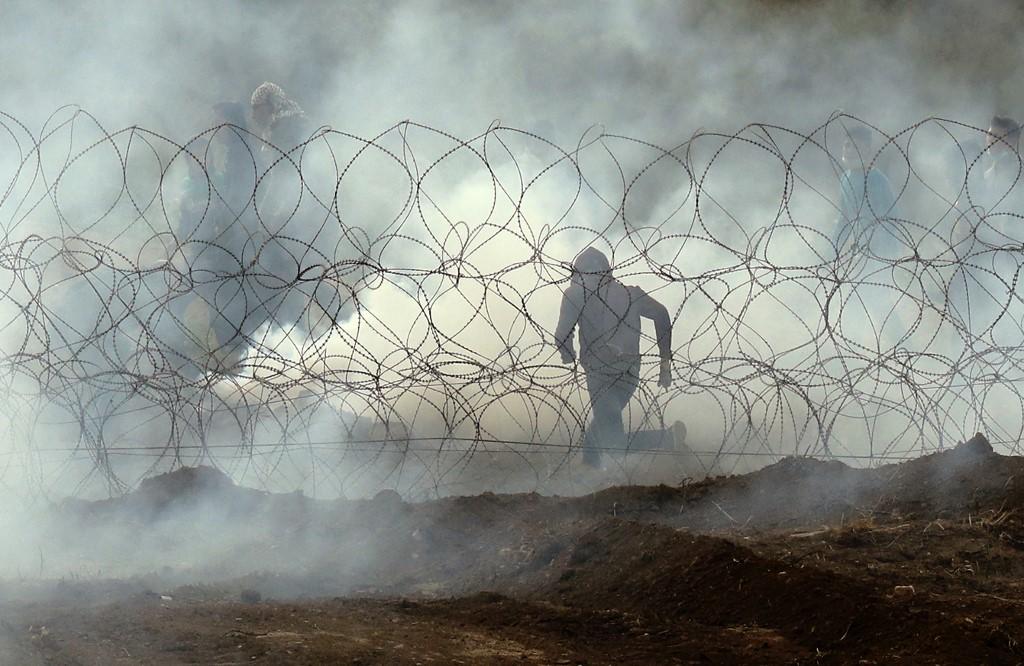 متظاهر فلسطيني خلال إطلاق الجيش الإسرائيلي قنابل مسيلة للدموع. أ ف ب 